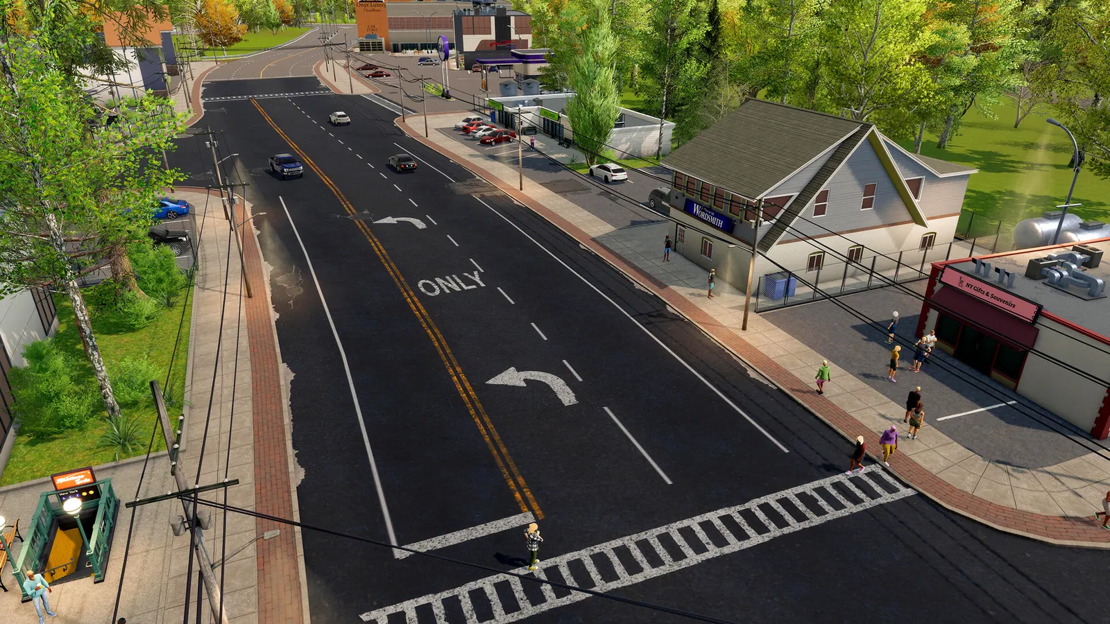 Two-lane suburban street with Wordsmith and NY Gifts & Souvenirs storefronts, a subway entrance and pedestrians.