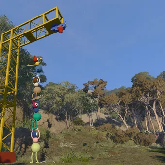 A tall yellow metal tower frame among granite boulders and eucalypts, with a chain of Big Walk characters climbing it one above another (May 2025 build)