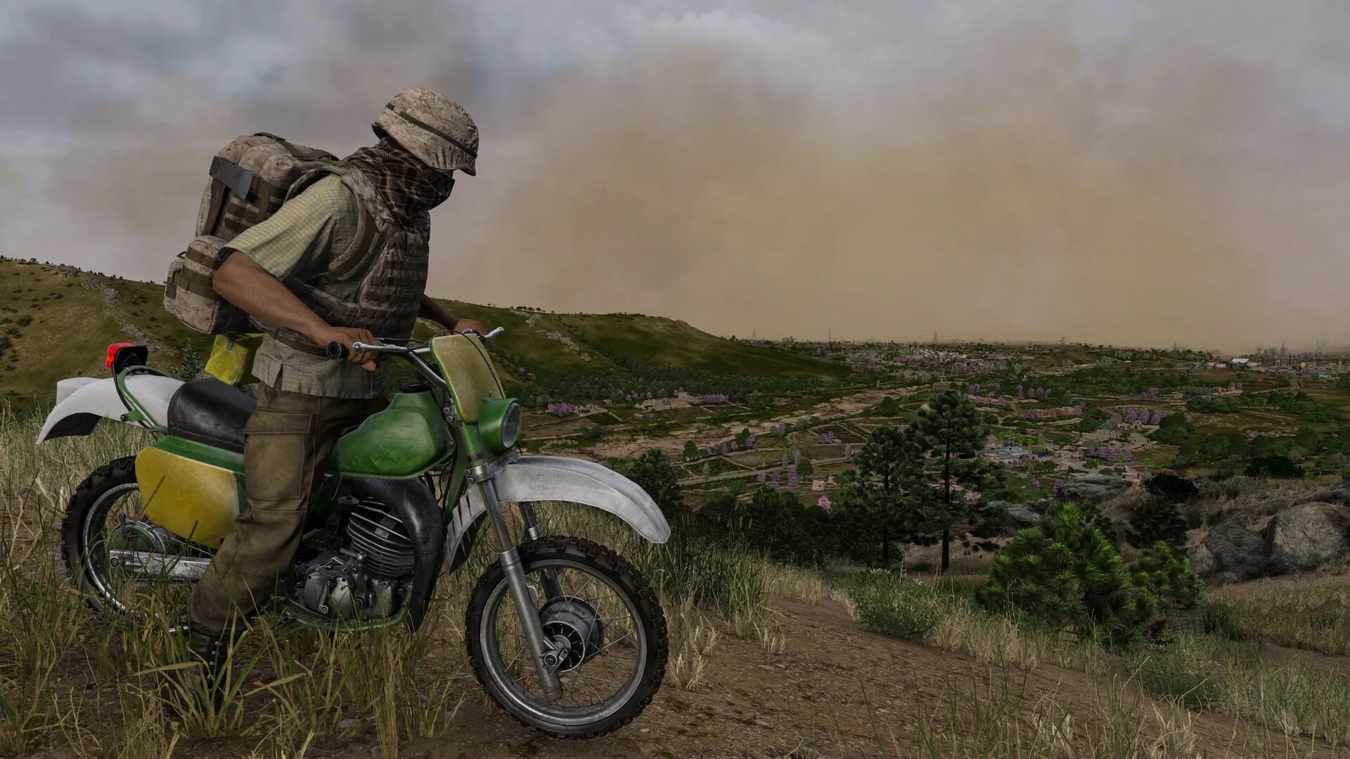 Rider on a green motorcycle in a dusty valley