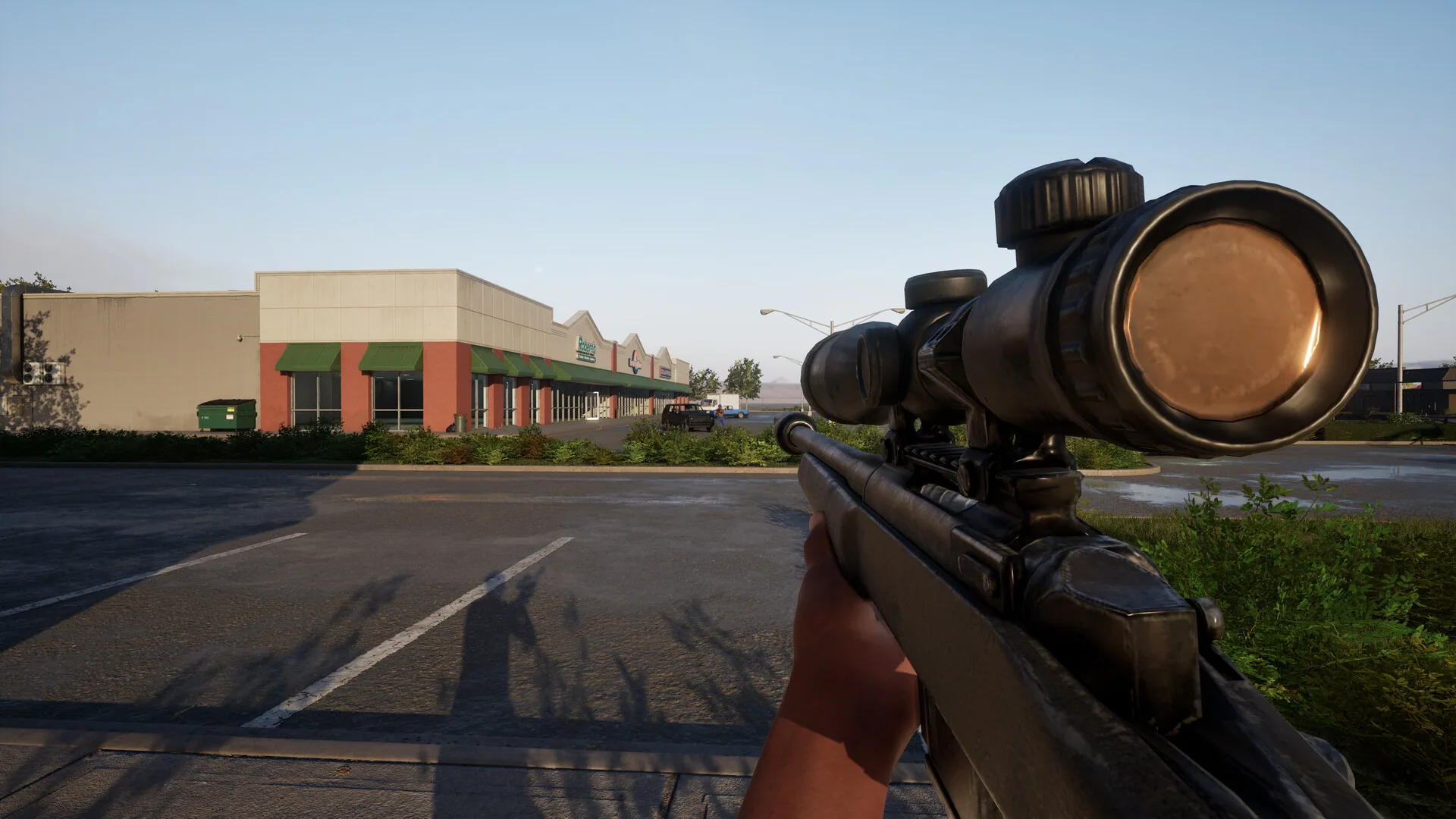 Scoped rifle over a strip-mall parking lot