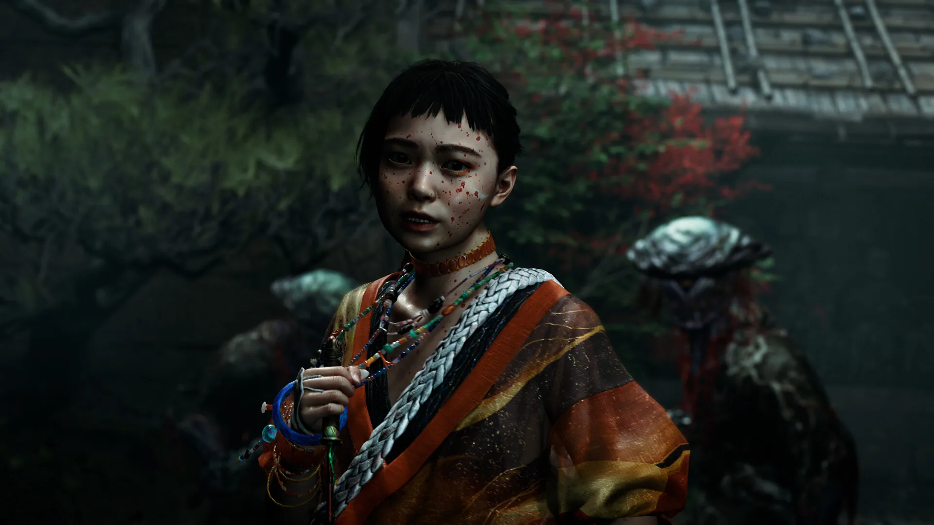 Young woman in orange kabuki-style robes and beads standing before Genma — official Izumo no Okuni screenshot
