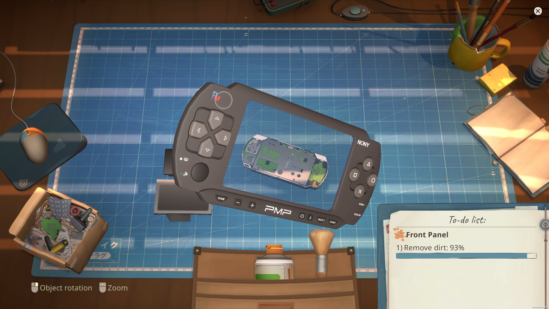 Overhead repair table with an opened handheld device, circuit board and remove-dirt task list.