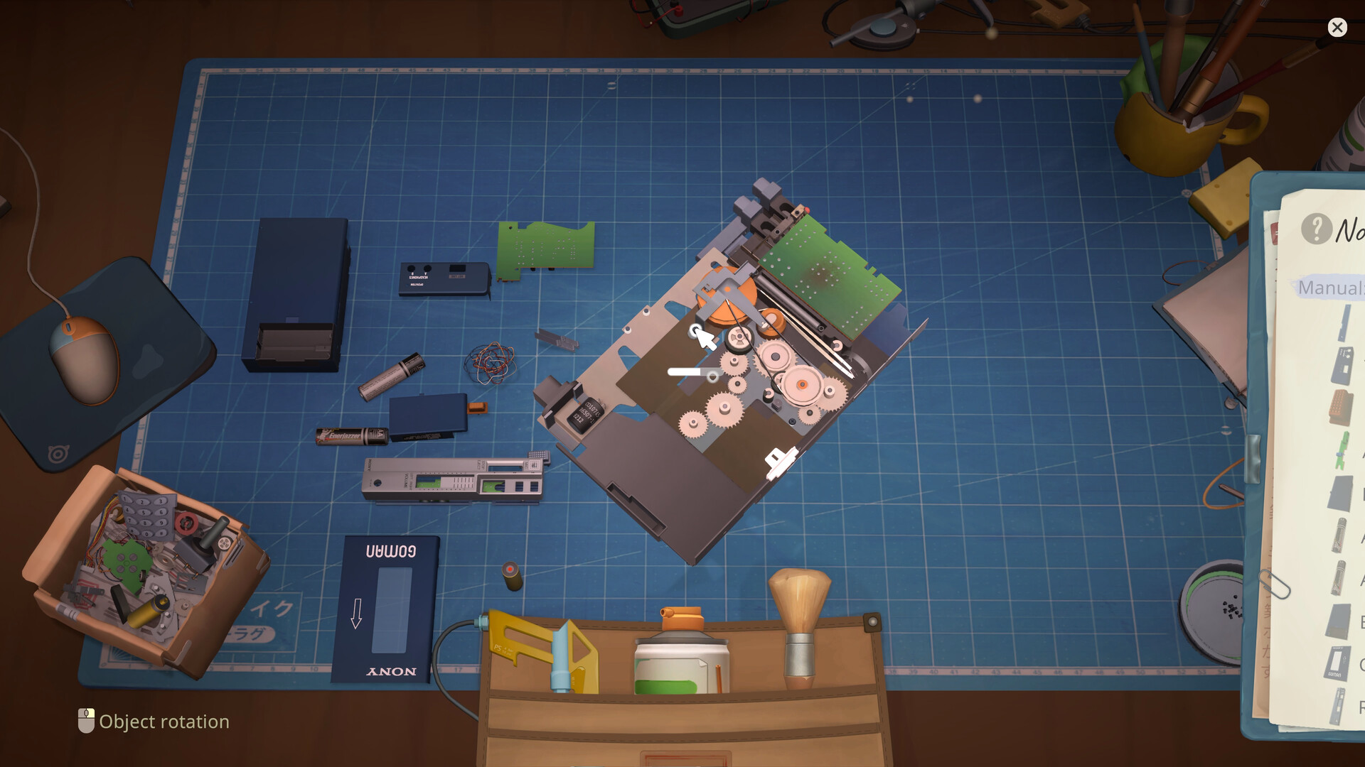 Opened device on a cutting mat with a separate board, casing and loose repair parts.