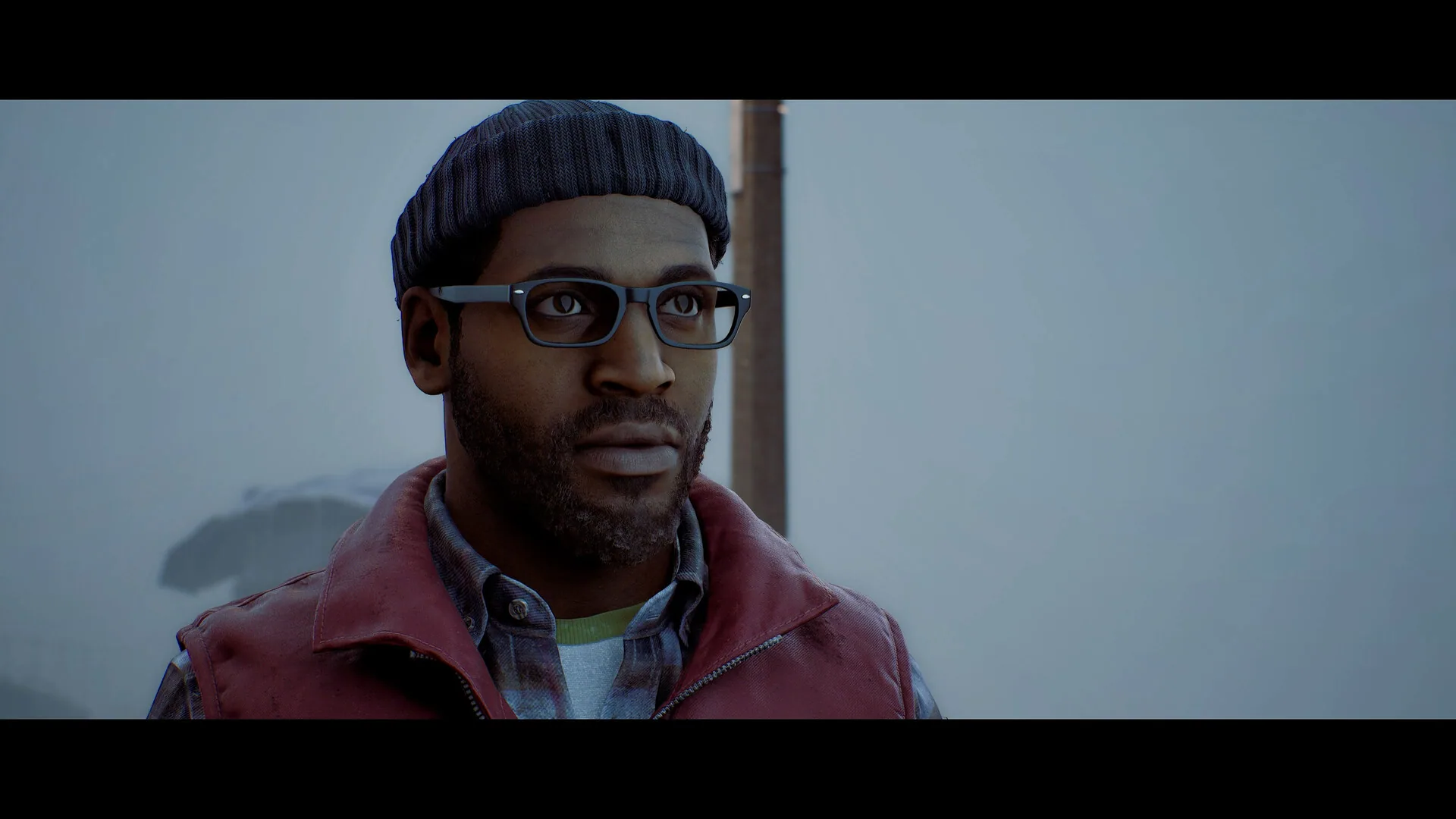Close-up of Simon Ordell in a burgundy vest, glasses, and knit cap against pale fog.