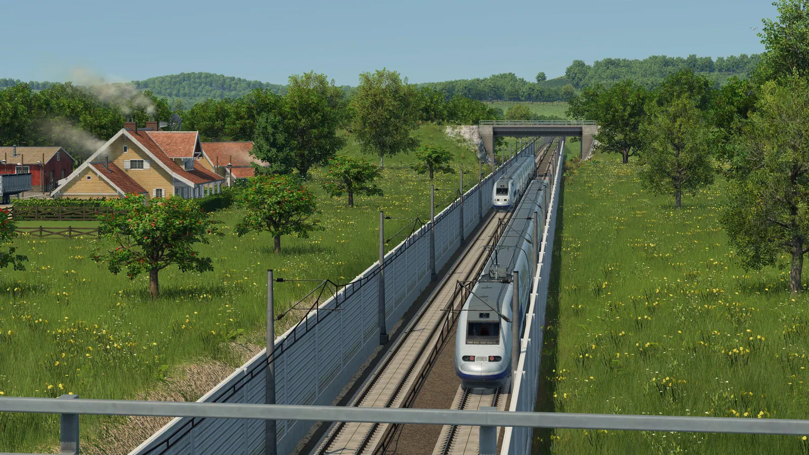 Silver high-speed trains on a fenced double track through farmland